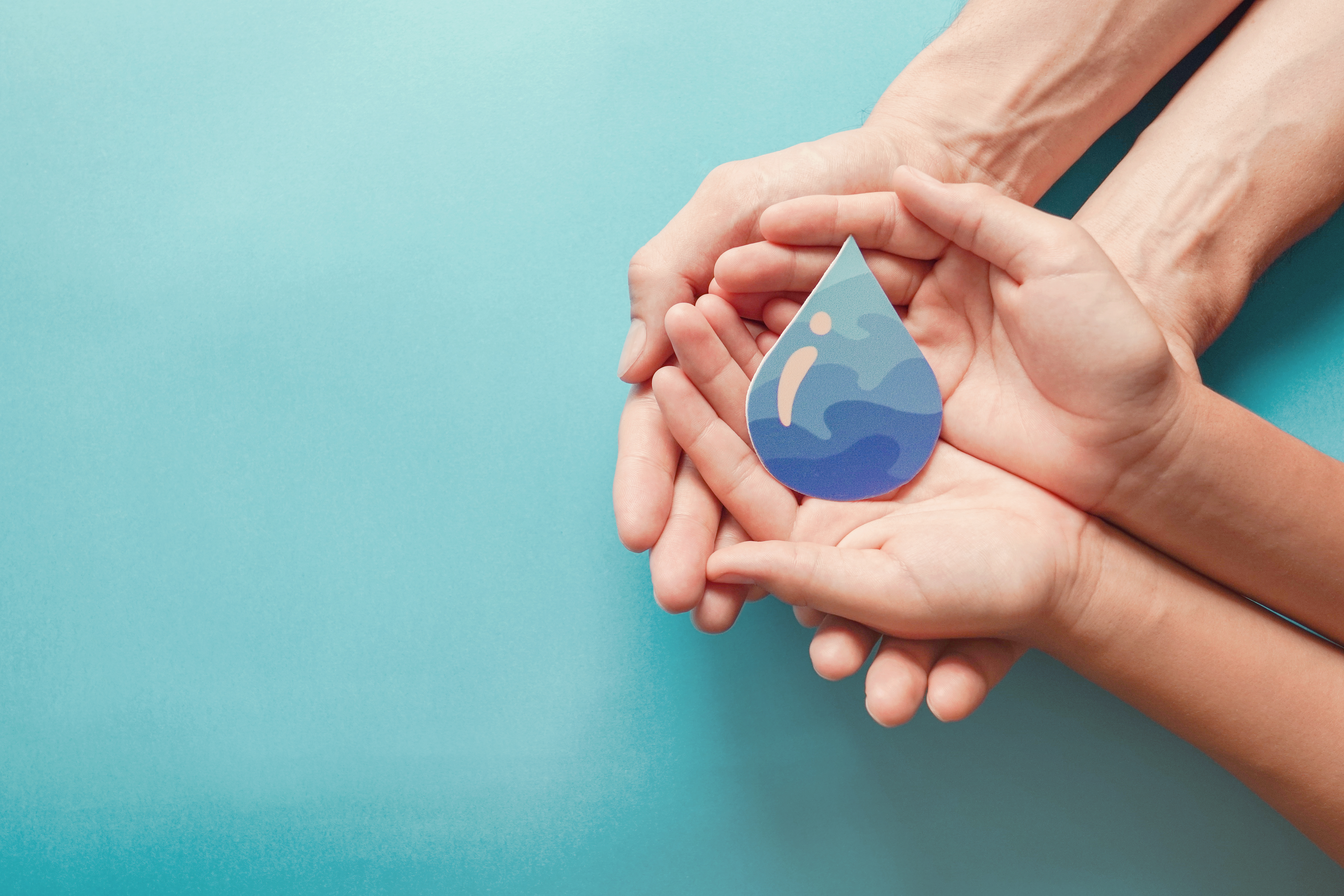 Mains tenant une goutte d'eau, symbole d'une gestion durable de l'eau en hôtellerie