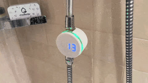 Le Molleaumètre en fonctionnement sous la douche : le compteur affiche 13 litres et l'anneau est vert
